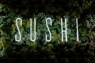 a neon sign that reads sushi surrounded by plants