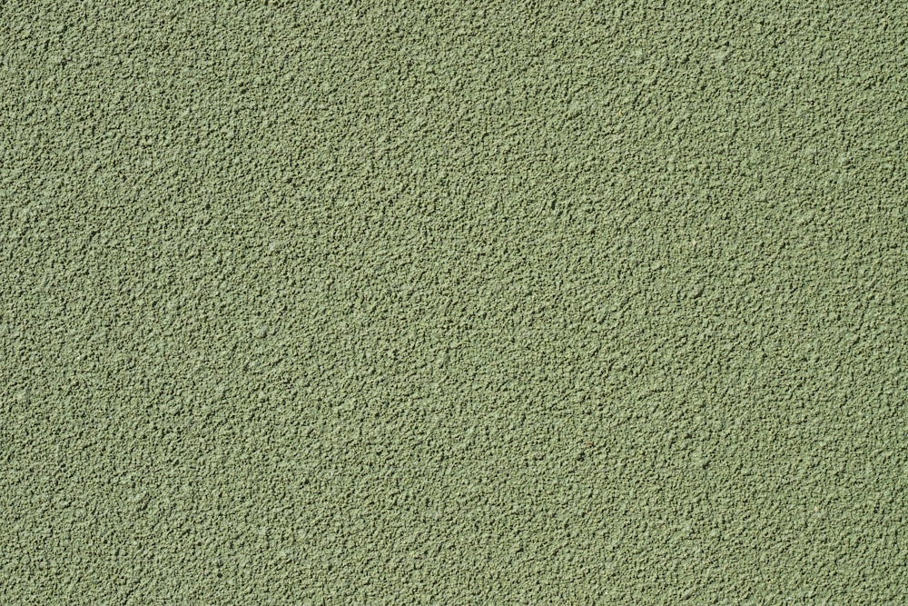 a close up of a green stucco wall
