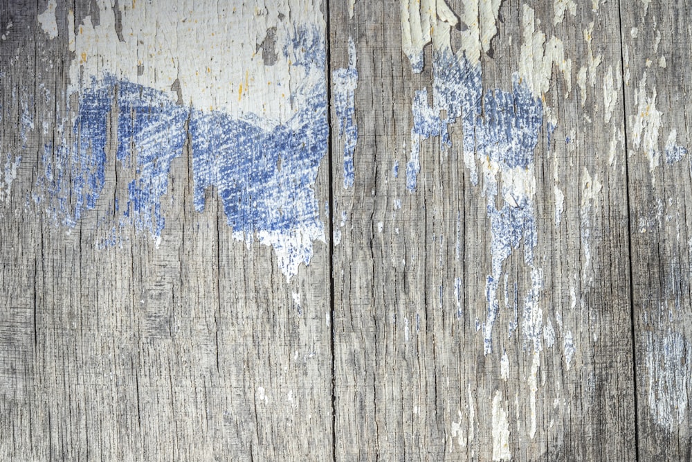 uma parede de madeira com tinta descascada sobre ela