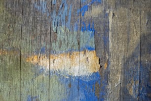 a close up of a wooden surface with blue and yellow paint