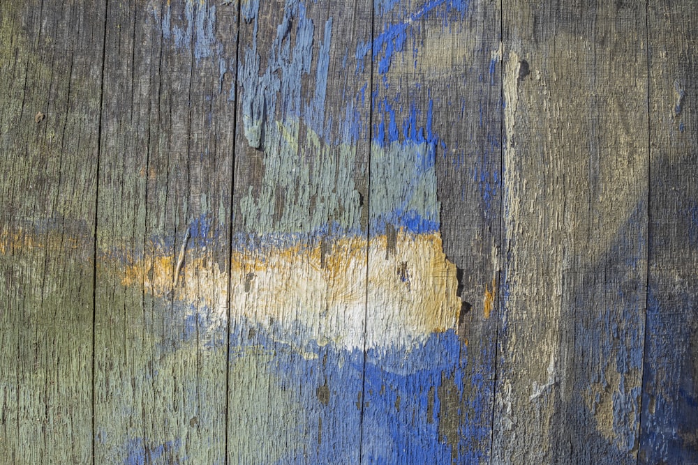 Gros plan d’une surface en bois avec de la peinture bleue et jaune