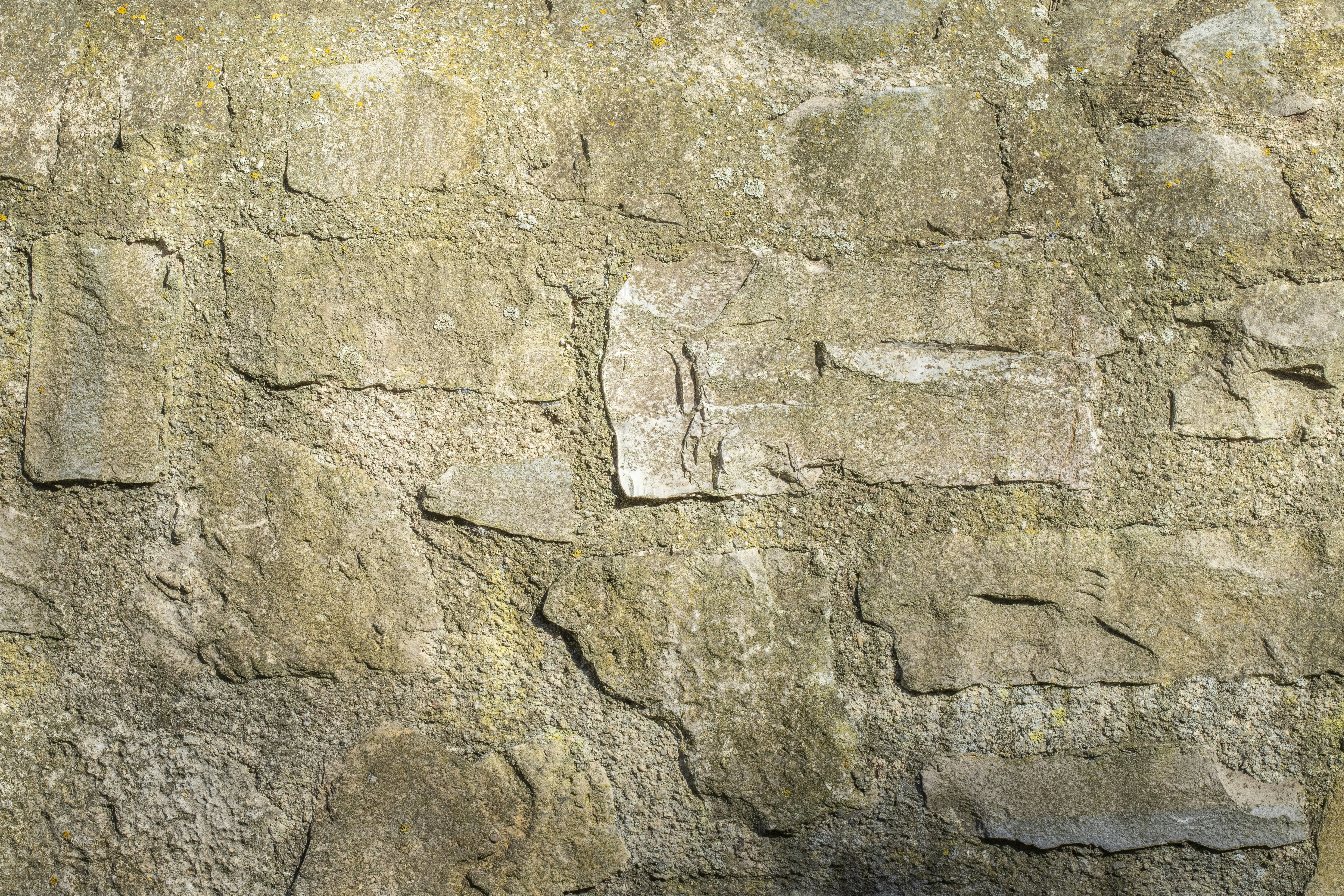 um close up de uma parede de pedra com um relógio sobre ele