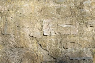 Un primer plano de un muro de piedra con un reloj