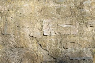 a close up of a stone wall with a clock on it