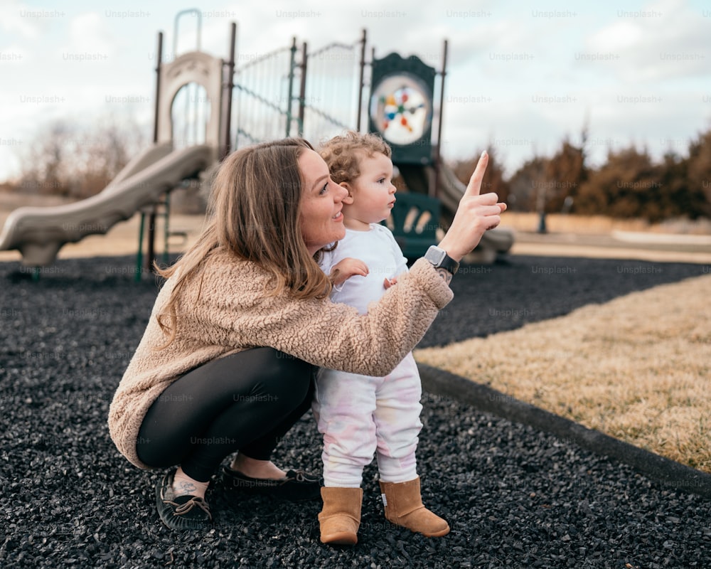 a woman taking a picture of a child on a playground