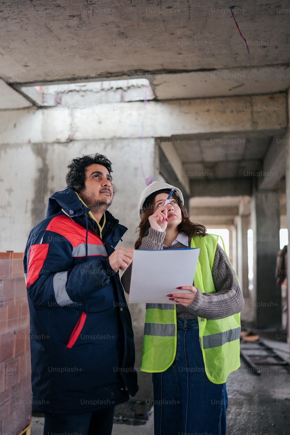 a man and a woman standing in a building under construction