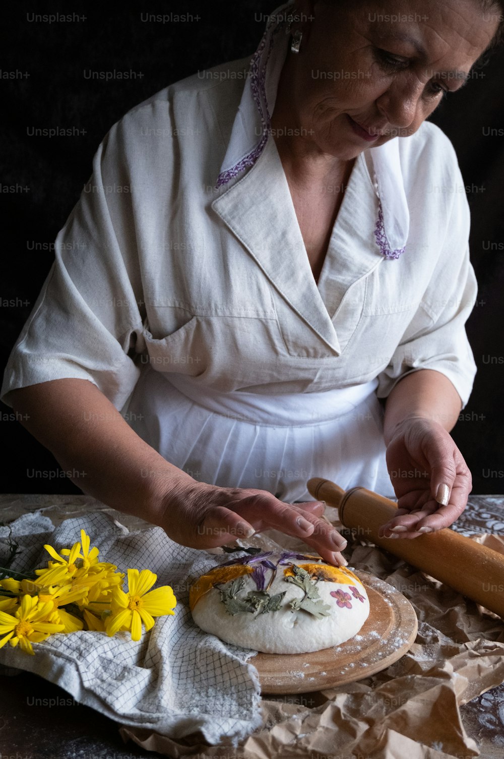 흰 셔츠를 입은 여자가 케이크를 만들고 있다