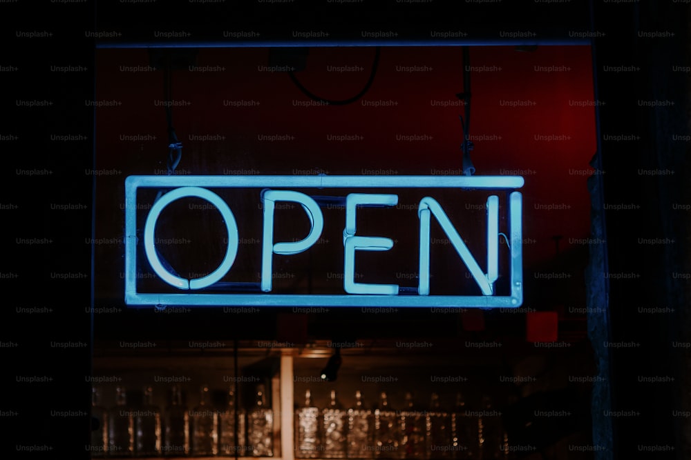 a neon open sign hanging from the side of a building