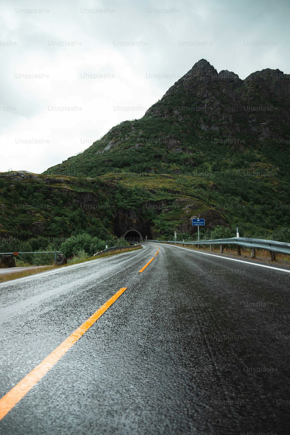 Eine nasse Straße mit einem Berg im Hintergrund