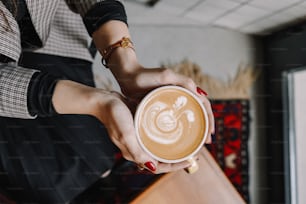 Eine Frau hält eine Tasse Kaffee in der Hand