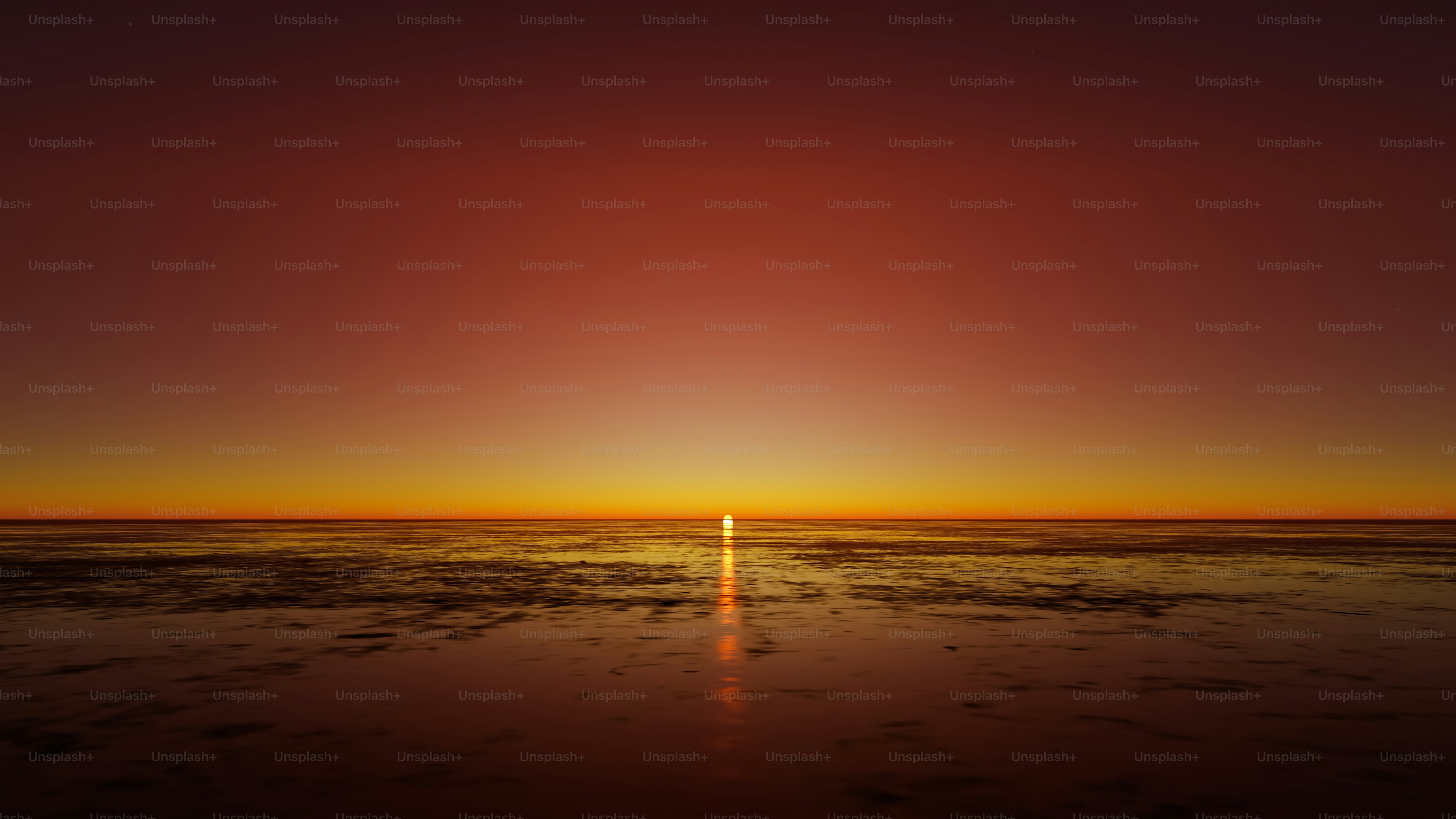 the sun is setting over the ocean on a clear day