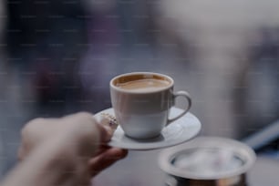 a close up of a person holding a cup of coffee