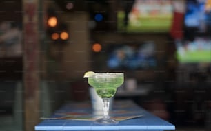 a green drink sitting on top of a blue counter