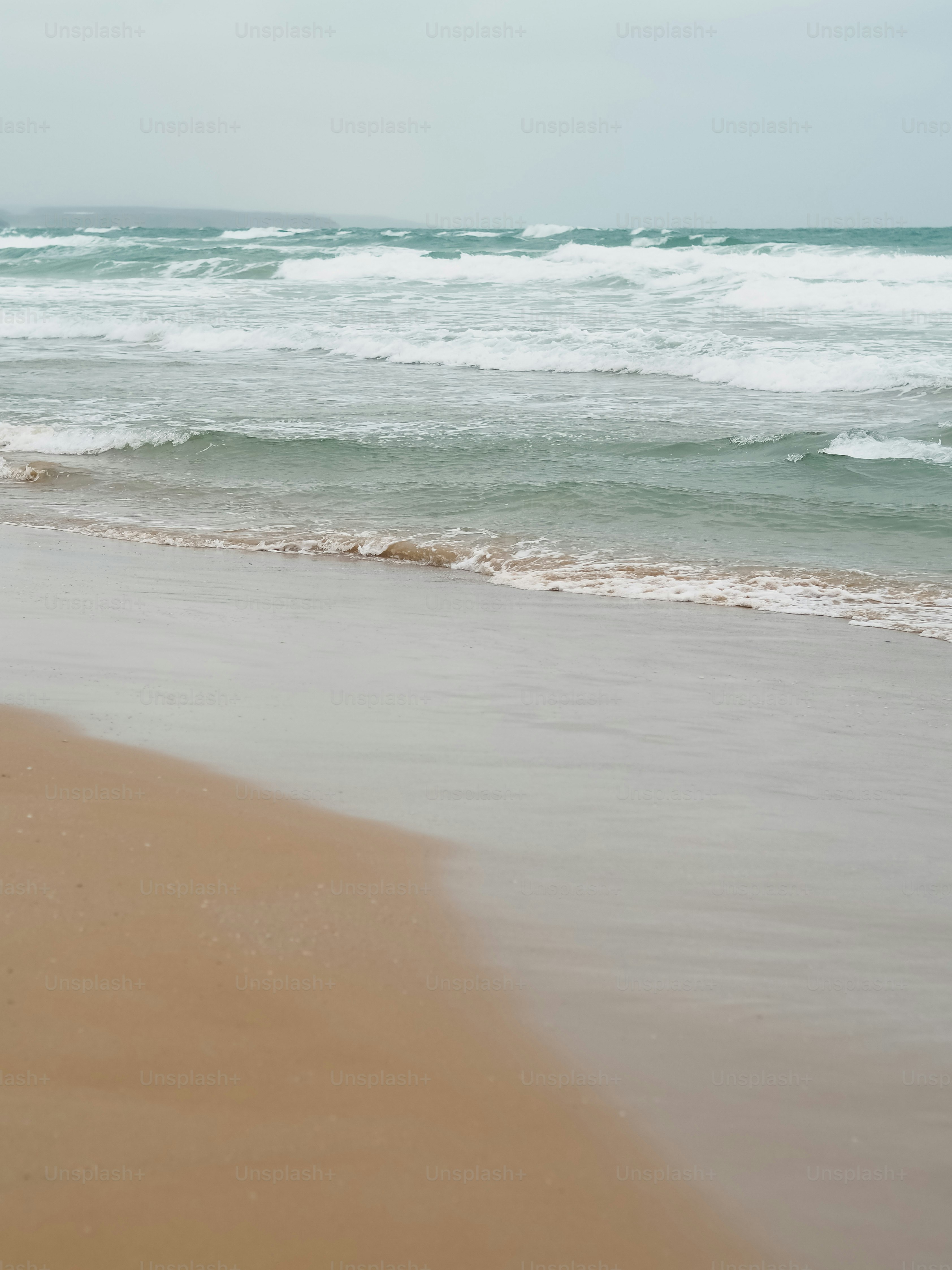 a person walking on the beach with a surfboard