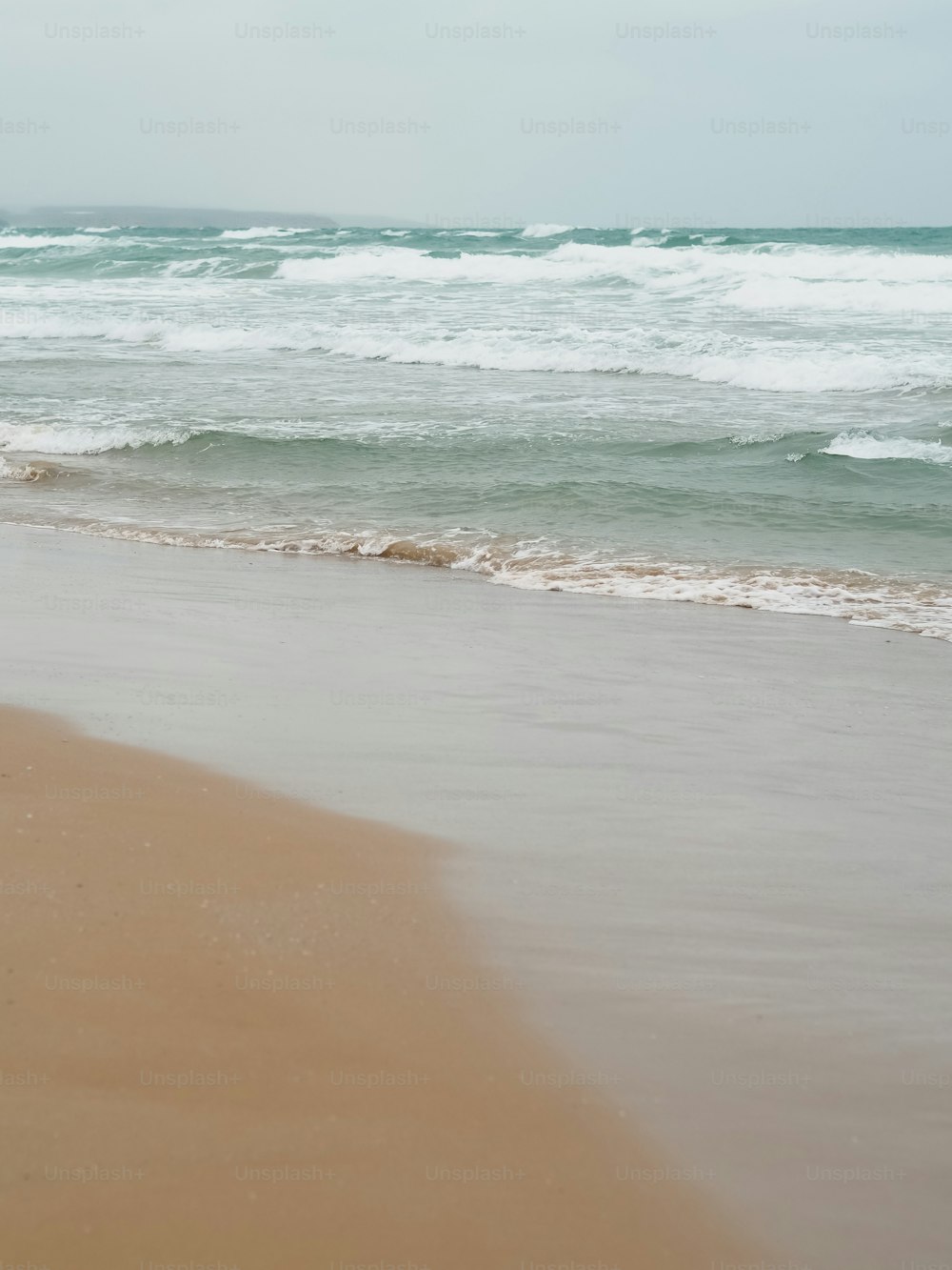 una persona che cammina sulla spiaggia con una tavola da surf