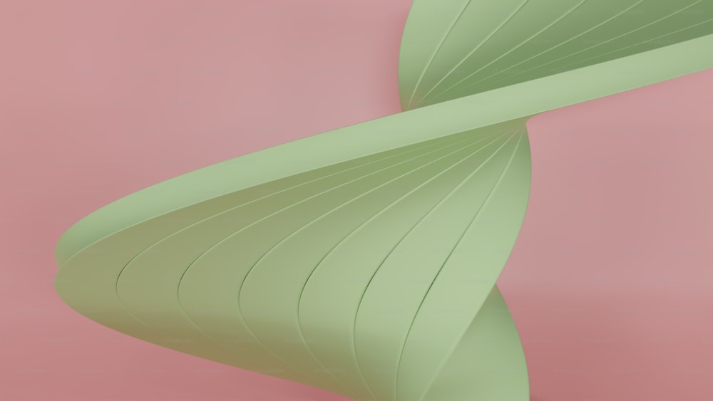 a close up of a green object on a pink background
