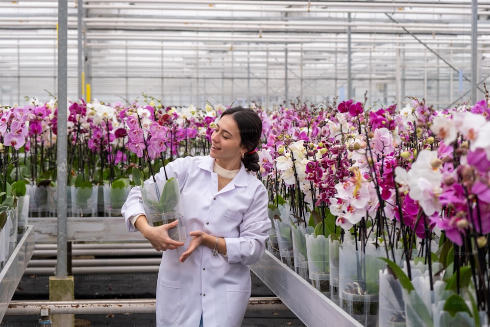a woman in a greenhouse holding a bunch of flowers