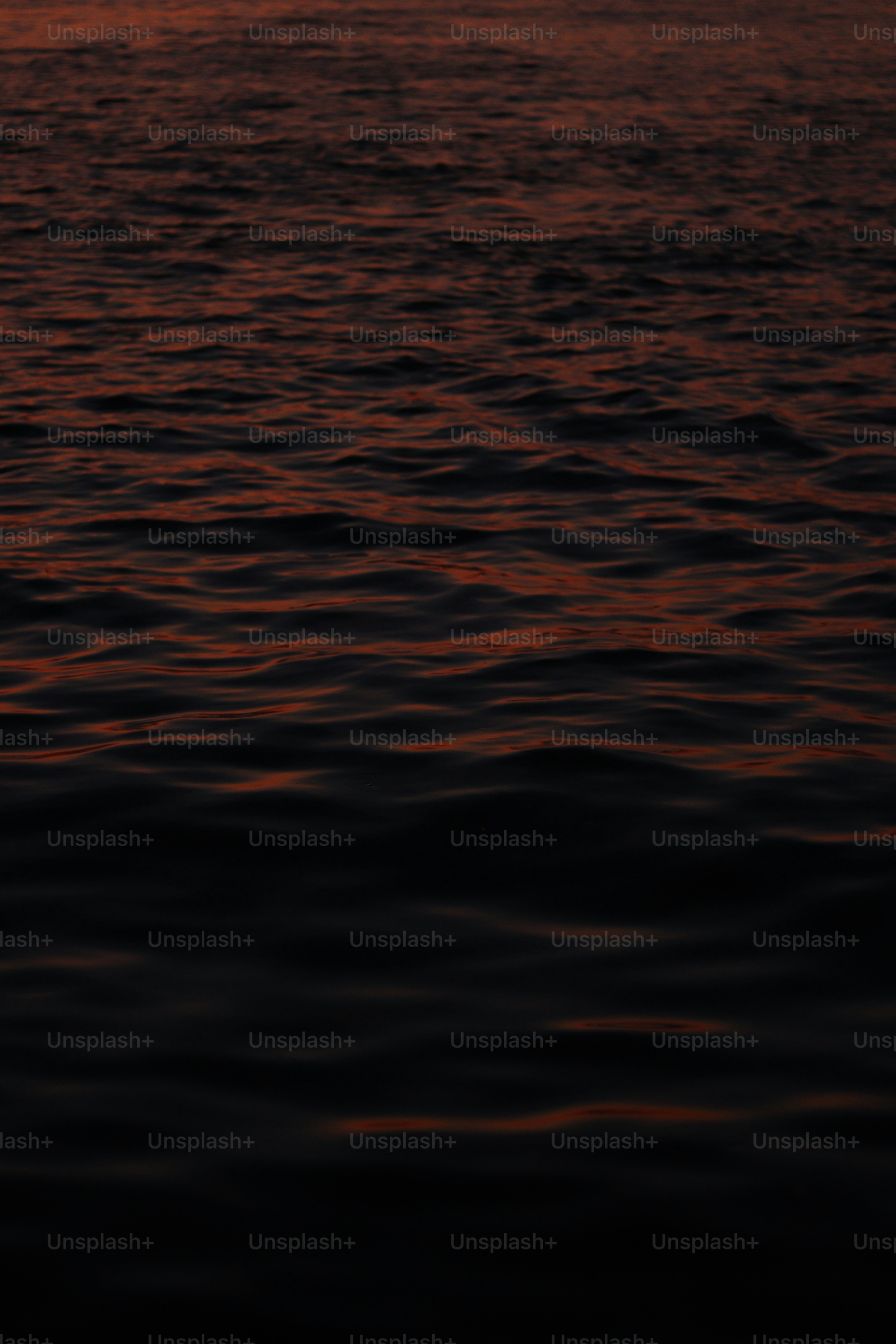 a sunset over a body of water with a boat in the distance