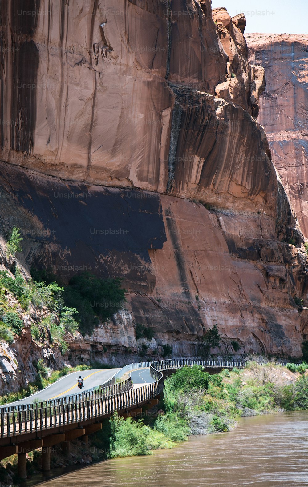 a person riding a bike on a bridge over a river