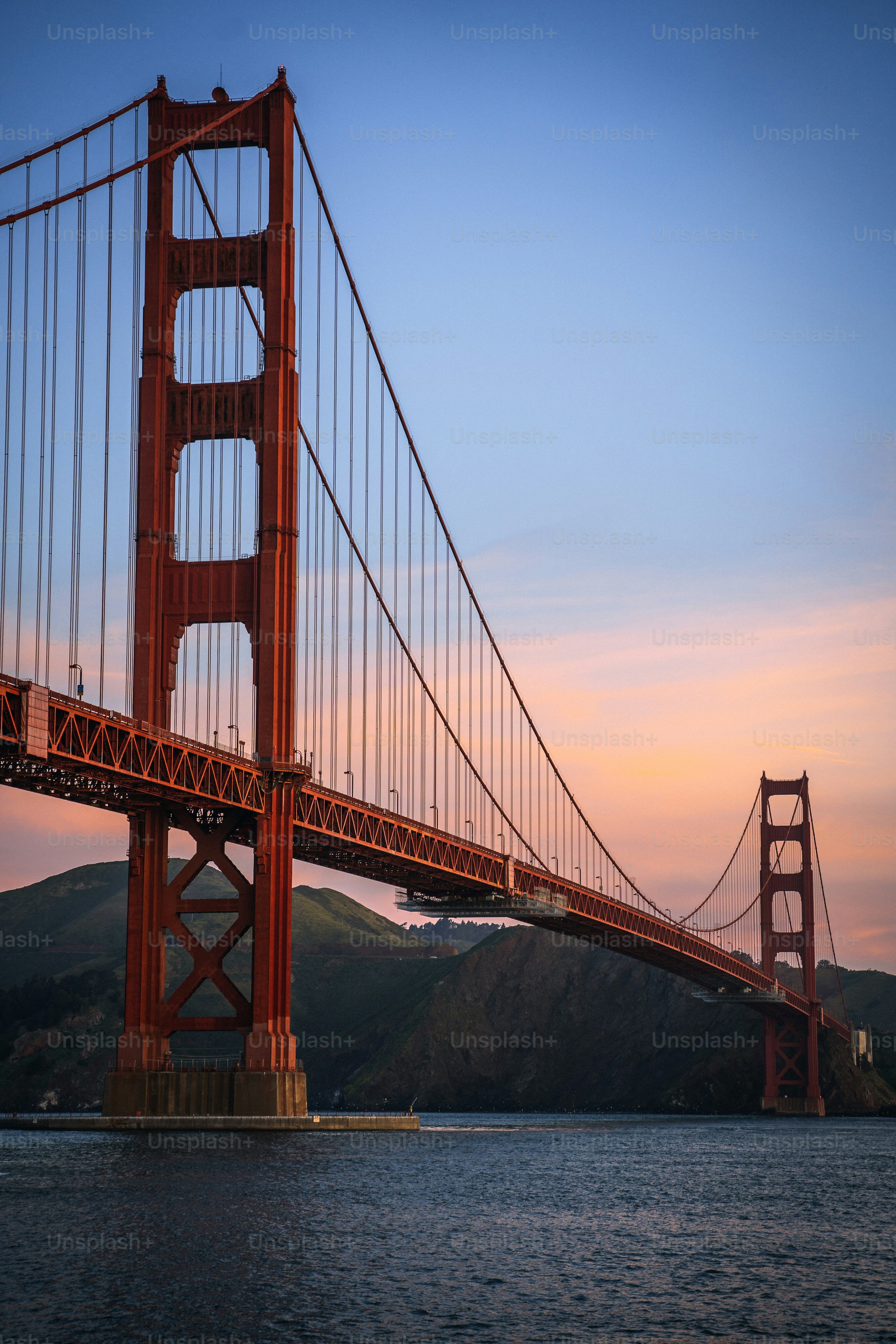 the golden gate bridge at sunset as seen from the water