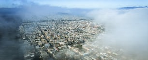 an aerial view of a city surrounded by clouds