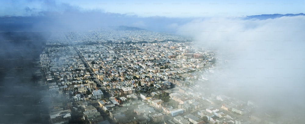 an aerial view of a city surrounded by clouds