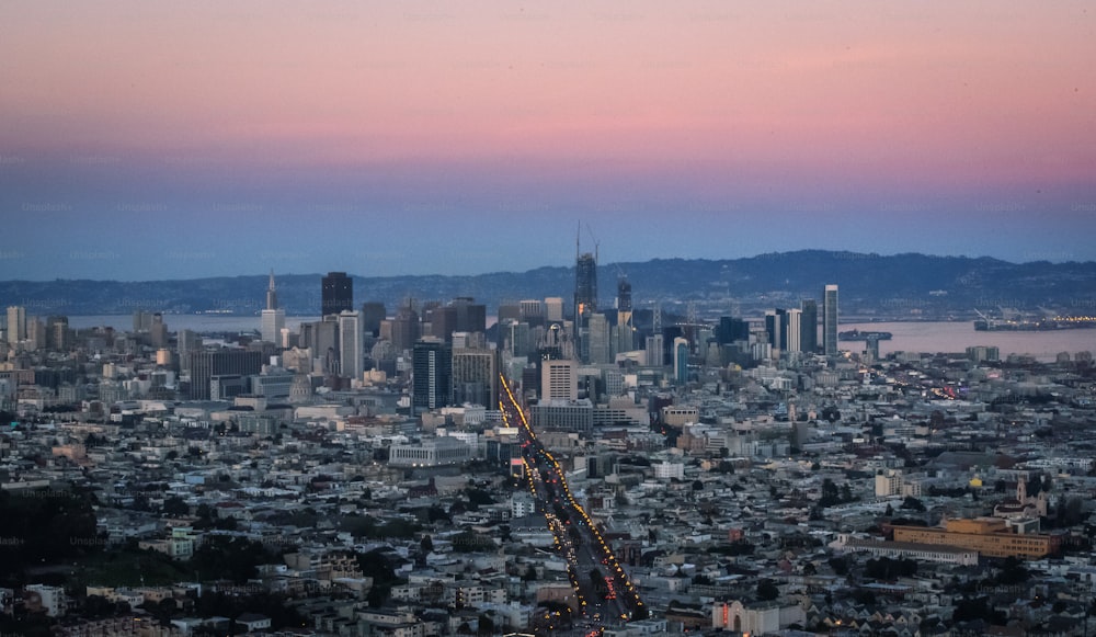 a view of a city at dusk with a pink sky