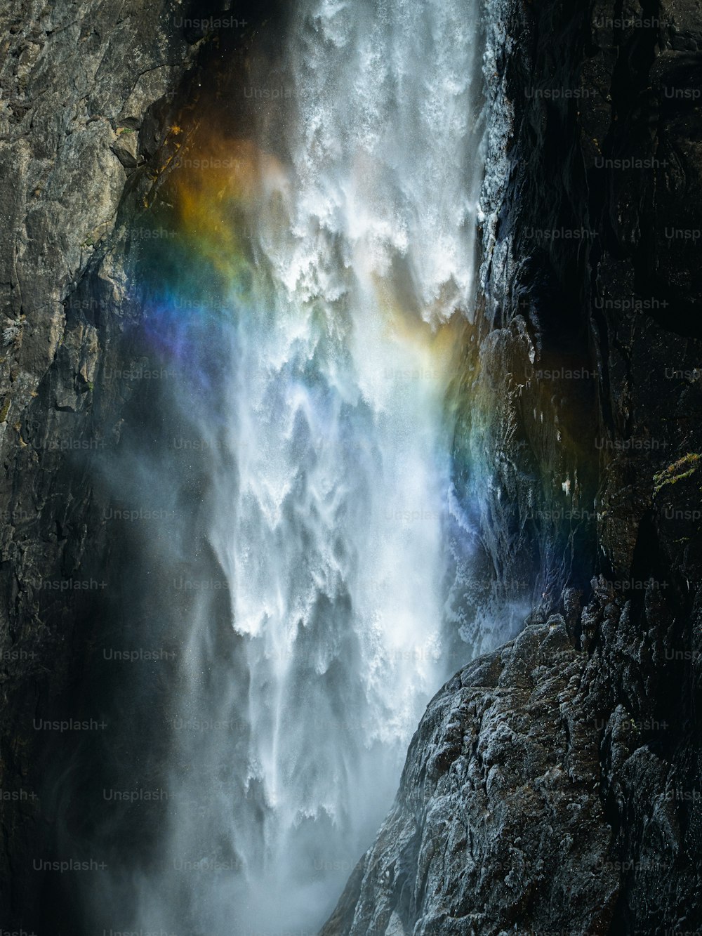 uma cachoeira com um arco-íris no meio dela