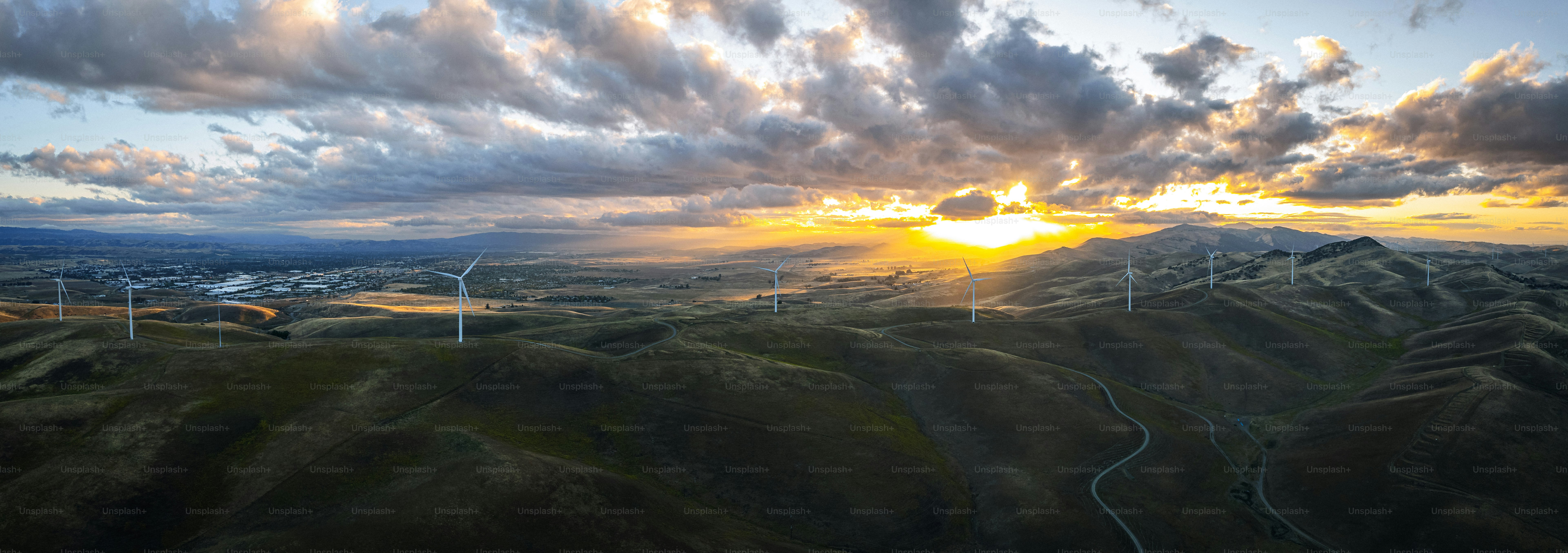 El sol se está poniendo sobre las colinas y los molinos de viento