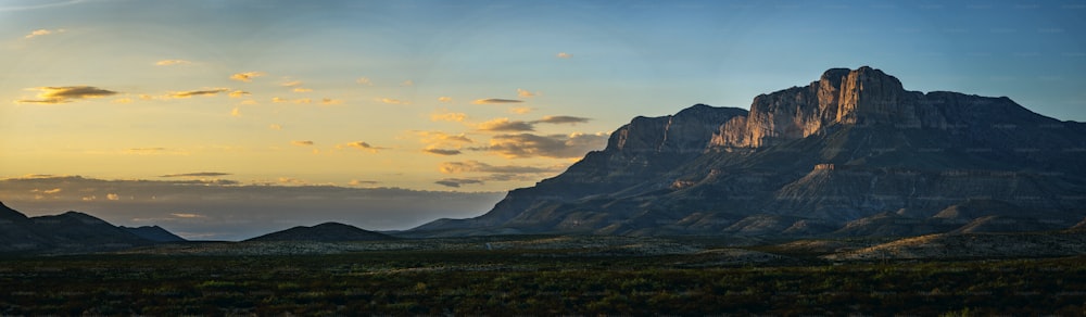 the sun is setting over a mountain range