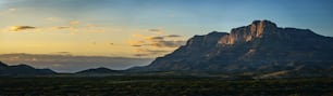 the sun is setting over a mountain range