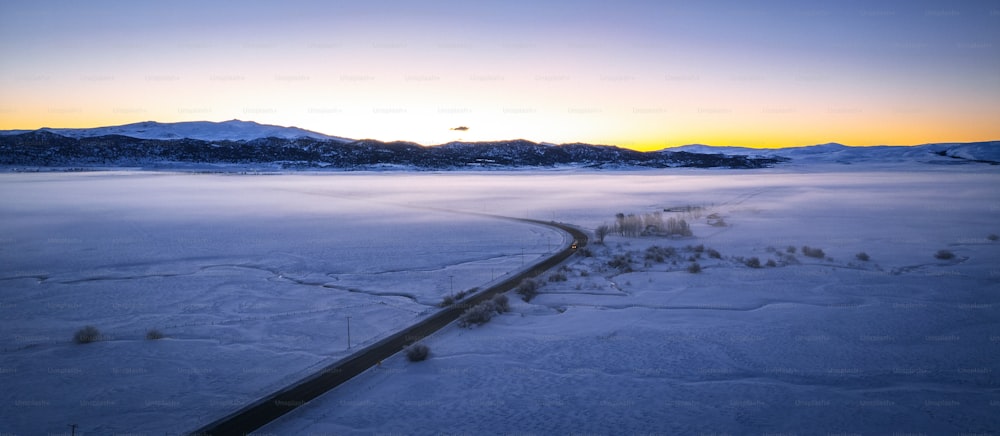 uma estrada no meio de um campo coberto de neve
