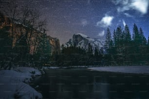 the night sky over a mountain and a lake