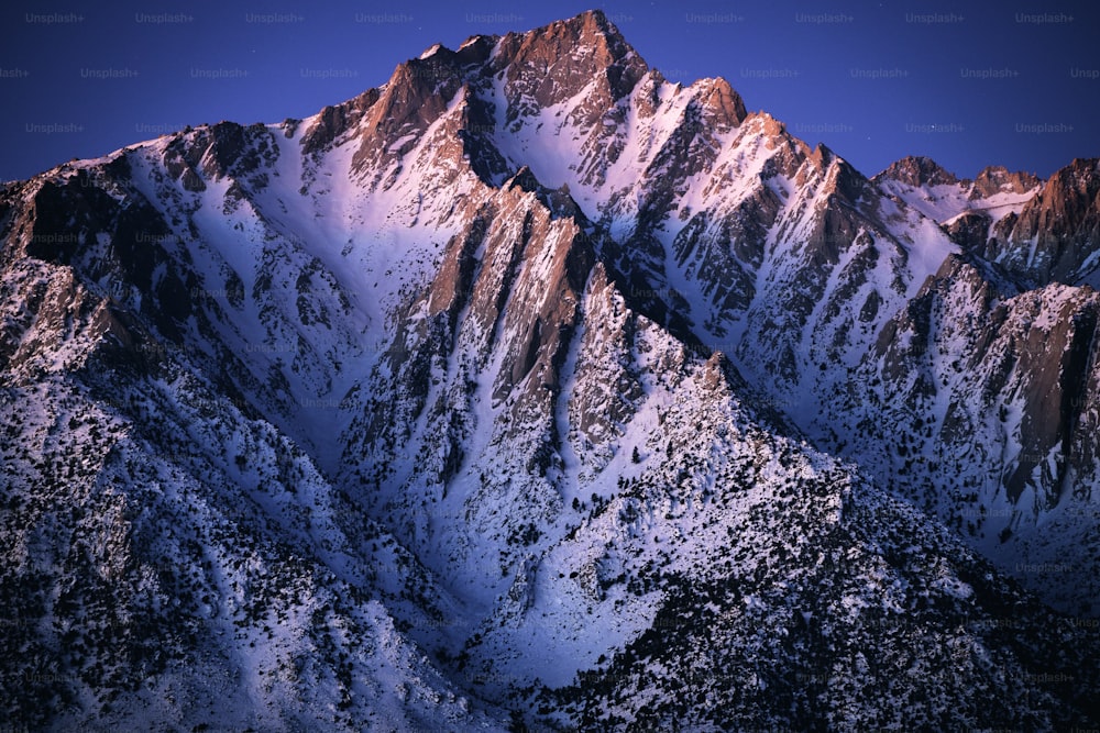 uma montanha coberta de neve com um céu azul claro