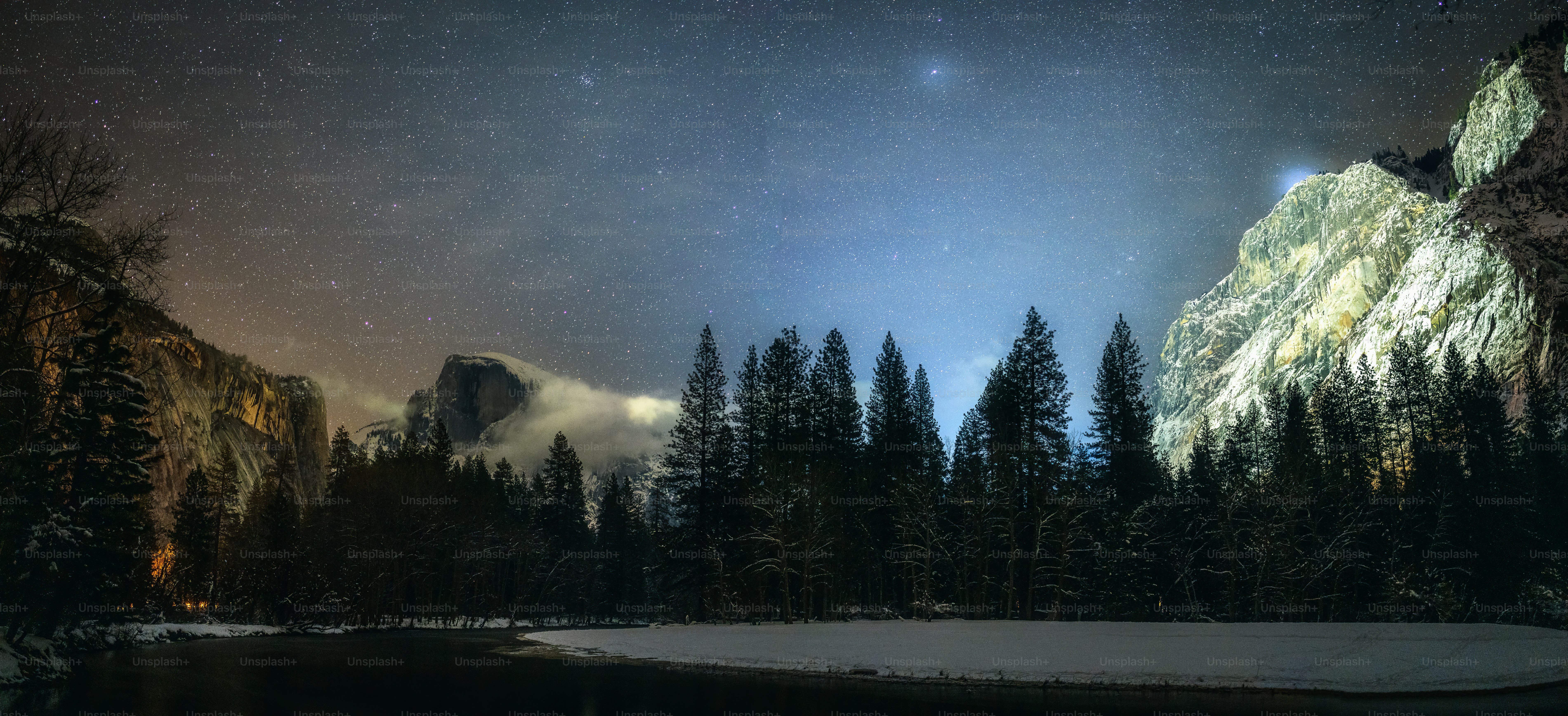 the night sky over a mountain and a lake