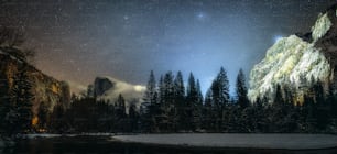 El cielo nocturno sobre una montaña y un lago