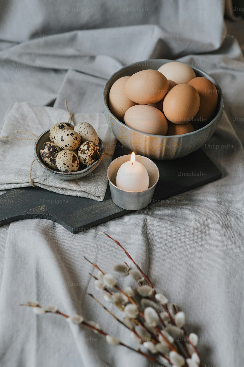 un tazón de huevos y una vela sobre una mesa