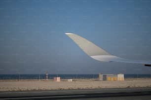 the wing of an airplane flying over a beach