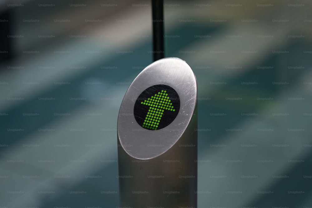 um close up de um sinal de seta verde em um poste