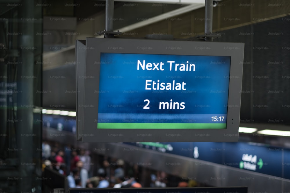 a train sign hanging from the ceiling of a train station