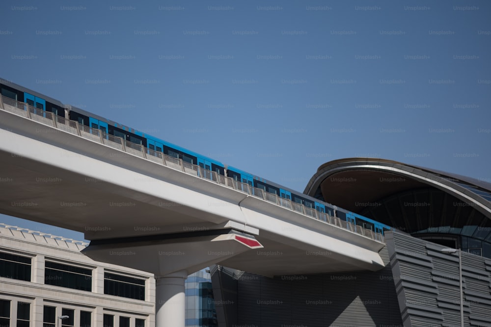 Un tren azul y blanco viajando sobre un puente