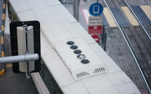 a street sign on a pole next to a train track