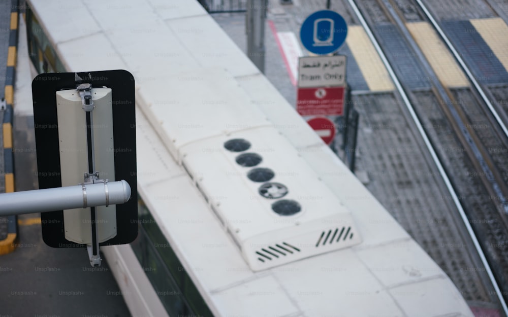 a street sign on a pole next to a train track