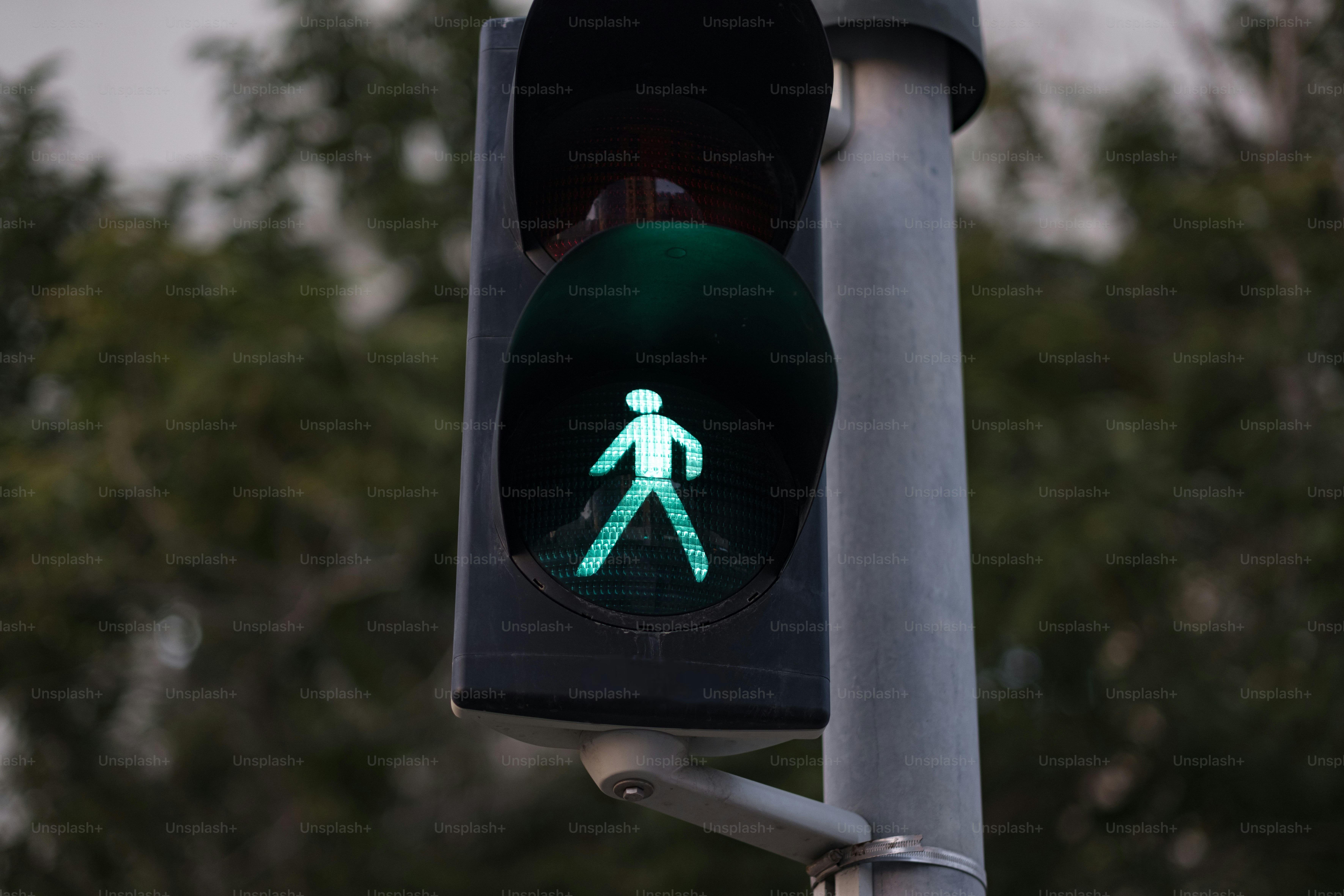 a traffic light with a green pedestrian sign on it