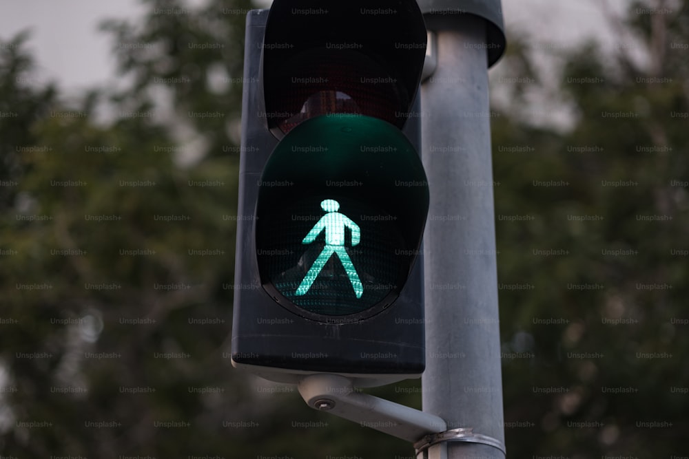 a traffic light with a green pedestrian sign on it