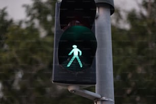 um semáforo com um sinal de pedestre verde sobre ele