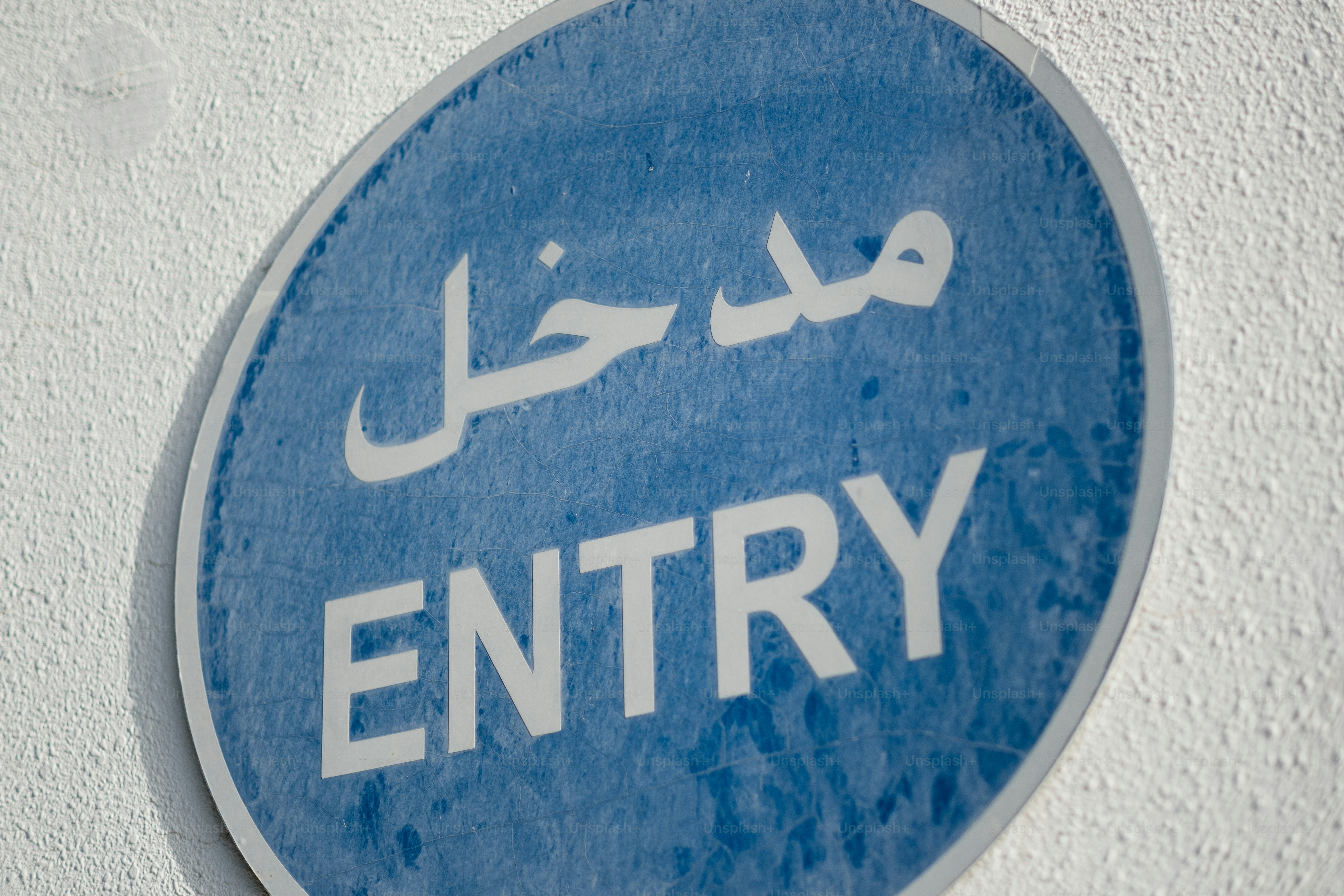 An entry / مدخل sign in English and Arabic.