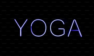 a neon sign that says yoga on a black background