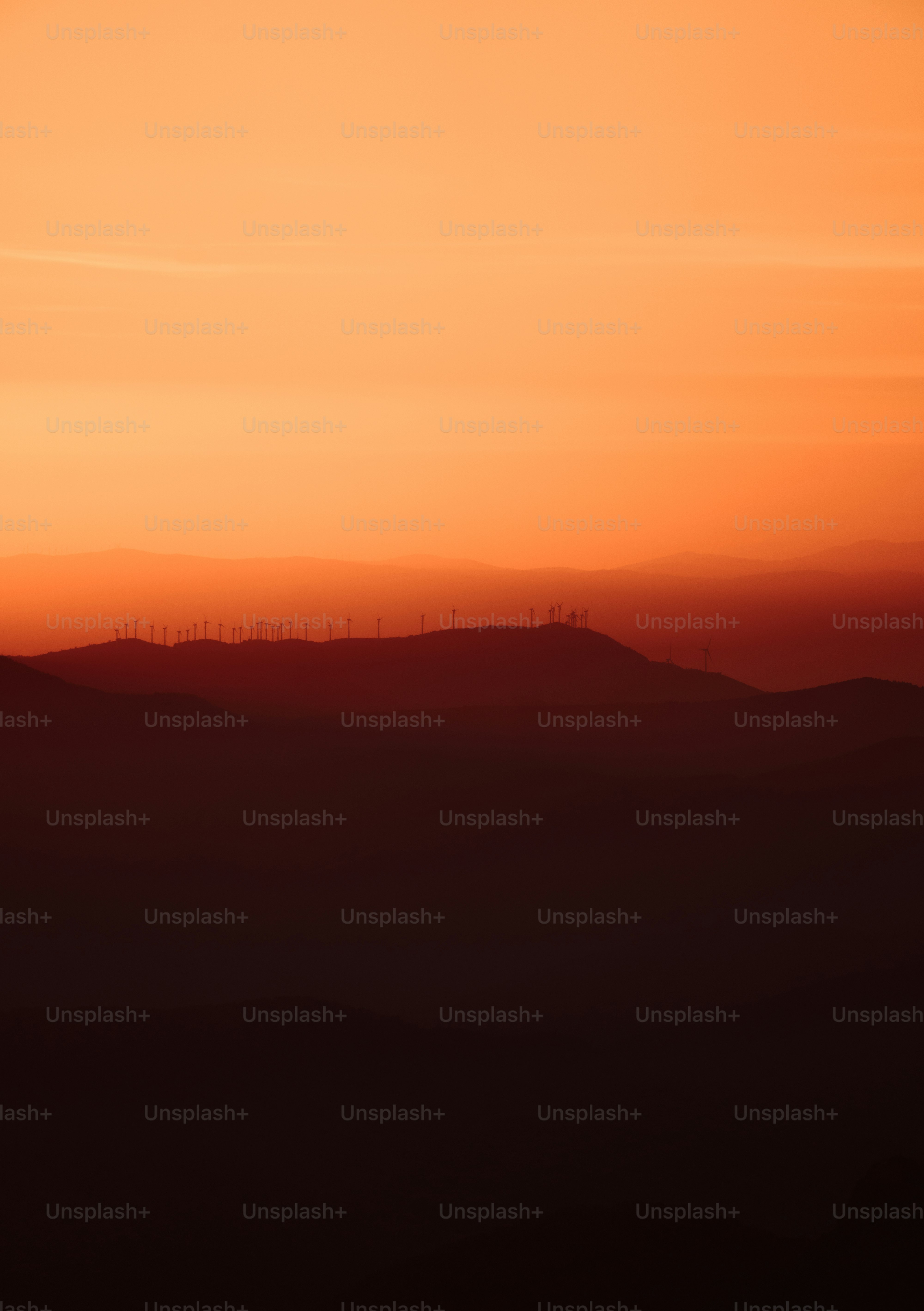 the sun is setting over a mountain range