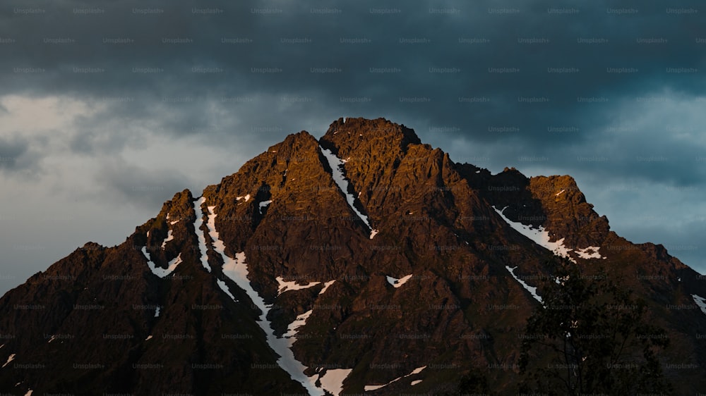 Ein sehr hoher Berg mit Schnee bedeckt unter einem bewölkten Himmel